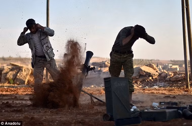 Hai chiến binh nổi dậy Syria bịt tai khi bắn súng cối. Ảnh Daily Mail