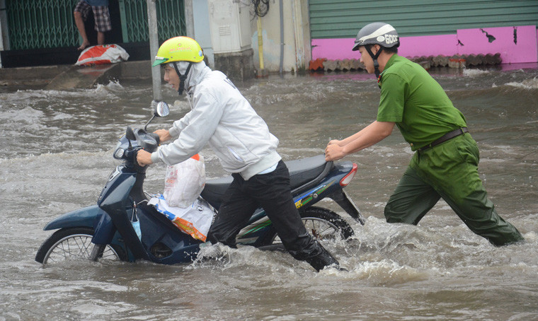 Các chiến sĩ Công an phường giúp dân qua vùng ngập.