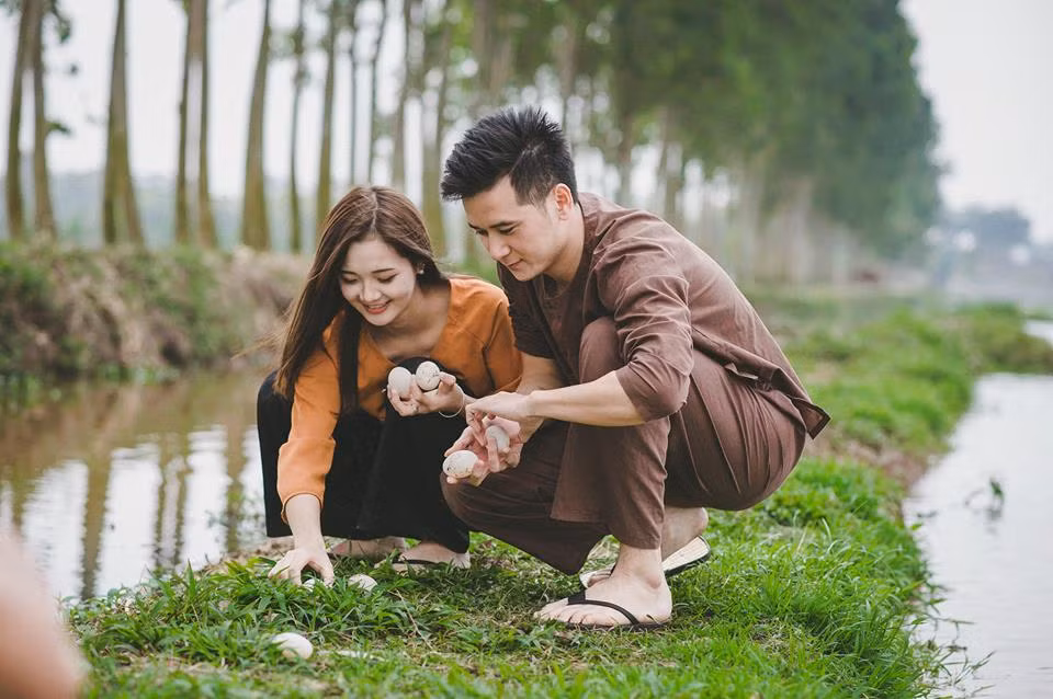 Khung cảnh đồng quê, những công việc quen thuộc của nhà nông như nhặt rau bên giếng nước, đi "mót" trứng vịt bên bờ ruộng... đã tạo nên không khí rất bình yên, tràn ngập tình cảm giản dị cho bộ ảnh cưới của "hot girl dân tộc" nổi tiếng mạng xã hội.