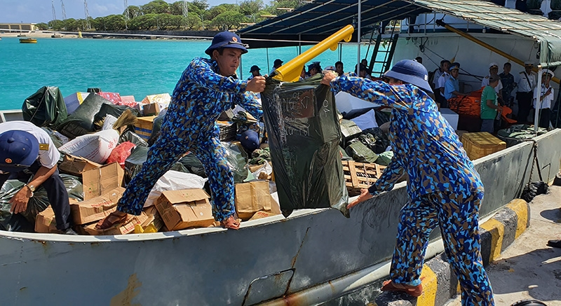Từng kiện hàng được kiểm đếm tỷ mỉ, đảm bảo mọi mặt hàng đều đến đúng tay người nhận và không thiếu sót bất cứ thứ gì. Nguồn ảnh: QDND.