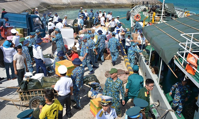 Lính đảo Trường Sa cùng bà con đang sinh sống trên đảo Trường Sa lớn tấp nập nhận quà Tết trên cầu cảng. Nguồn ảnh: QDND.