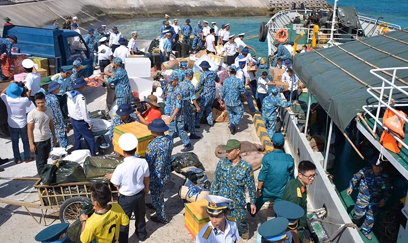 Lính đảo Trường Sa cùng bà con đang sinh sống trên đảo Trường Sa lớn tấp nập nhận quà Tết trên cầu cảng. Nguồn ảnh: QDND.