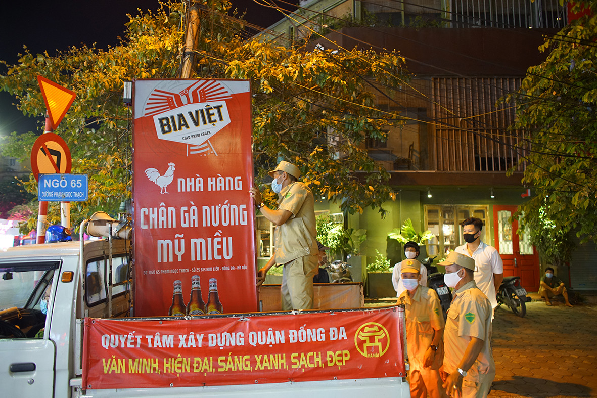 Khoảng 21h ngày 12/7, tổ công tác của Công an phường Kim Liên (Đống Đa, Hà Nội) đi nhắc nhở hàng quán đóng cửa đúng giờ quy định. Với những cửa hàng cố tình vi phạm, lực lượng chức năng sẽ lập biên bản xử phạt tại chỗ.