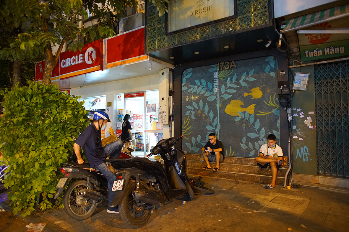 Hàng quán đóng cửa nên hệ thống siêu thị tiện dụng rất đông khách. Nhiều thanh niên mua đồ rồi ra các vỉa hè gần đó ngồi ăn uống dù đêm đã khuya.