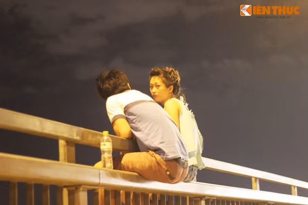 Để ngồi vắt vẻo trên thành cầu được lâu, cặp đôi này không quên mang theo chai nước uống sau khi tán chuyện khô cổ họng.