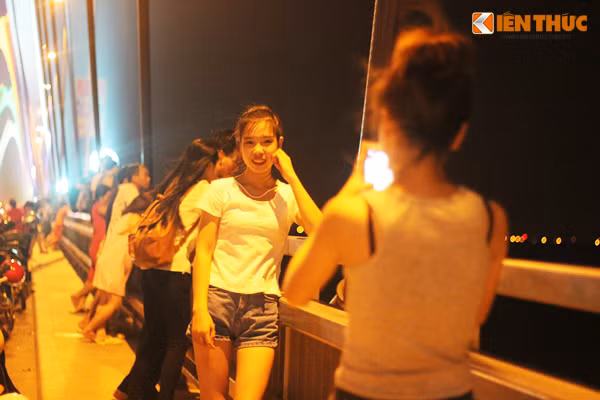 Ghi nhận của PV Kiến Thức những ngày đầu tháng 6, bắt đầu từ 20h, nhiều bạn trẻ đã đèo nhau bằng xe máy phóng lên cầu Nhật Tân và dựng xe thành hàng dài, sau đó đứng hóng mát, chụp ảnh "tự sướng".