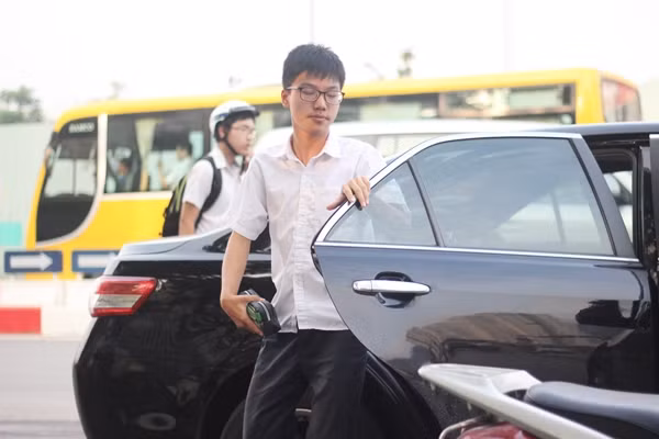 Dự đoán nhiều thí sinh sẽ được phụ huynh đưa đến điểm thi bằng ô tô ở trường Amsterdam nên ngay từ sáng sớm, lực lượng CSGT, TTGT Hà Nội đã có mặt để điều tiết giao thông, không để xảy ra ùn tắc đoạn đường và khu vực trước cổng trường thi. Ảnh: Nam sinh nhanh chóng rời khỏi xe ô tô để vào trường thi.