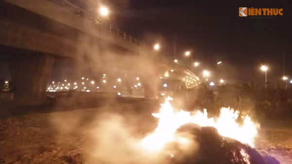 Đống rơm to đùng bốc cháy ngùn ngụt ngay dưới chân một cây cầu vượt trên tuyến đường Võ Nguyên Giáp như "nướng" những người di chuyển phía trên cầu.