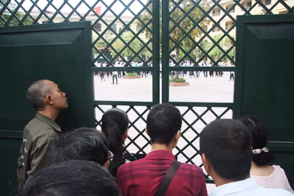 Nhiều phụ huynh vẫn đứng ngóng trông cho dù cửa trường thi đã khép.