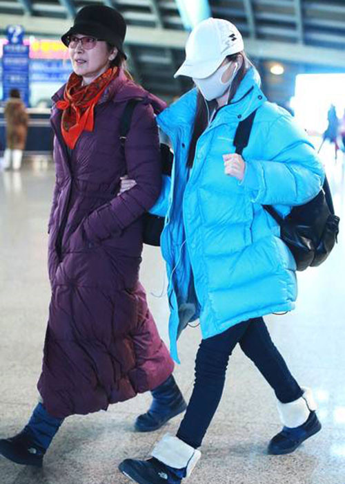 Lý Tiểu Lộ bịt khẩu trang kín mít và khoác chặt tay mẹ. Ảnh: Ifeng