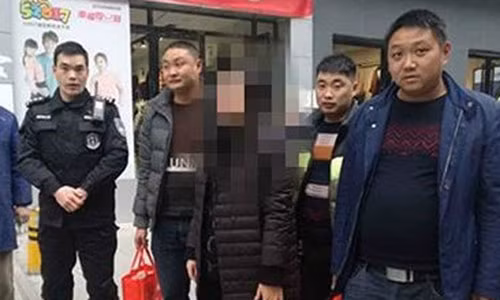 Cảnh sát hộ tống bà Lee cùng 5 túi vải đựng đầy tiền. Ảnh: Sina