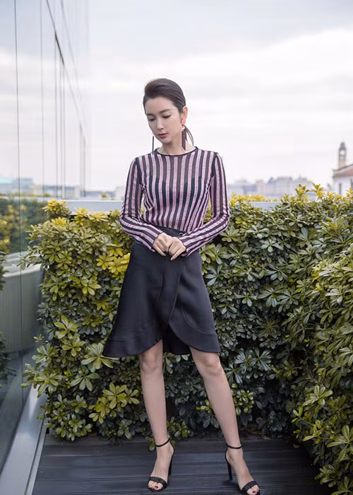 Tham gia sự kiện, nữ diễn viên diện set trang phục gồm áo kẻ sọc kết hợp với chân váy xẻ trước giống hệt bông hoa tulip. Ảnh: Sina