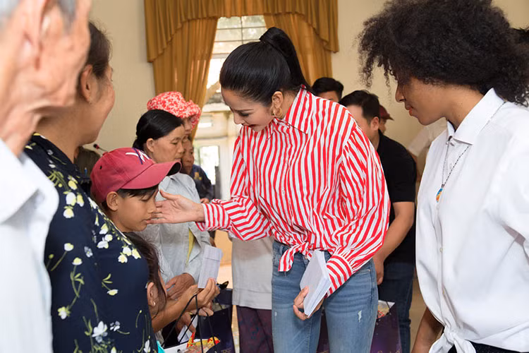 Hình ảnh Hoàng Thùy ân cần trao quà từ thiện cho người dân.