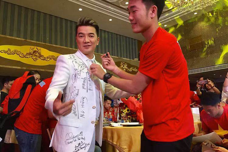 Xuân Trường ký tặng lên chiếc áo đã đầy chữ ký của Đàm Vĩnh Hưng.