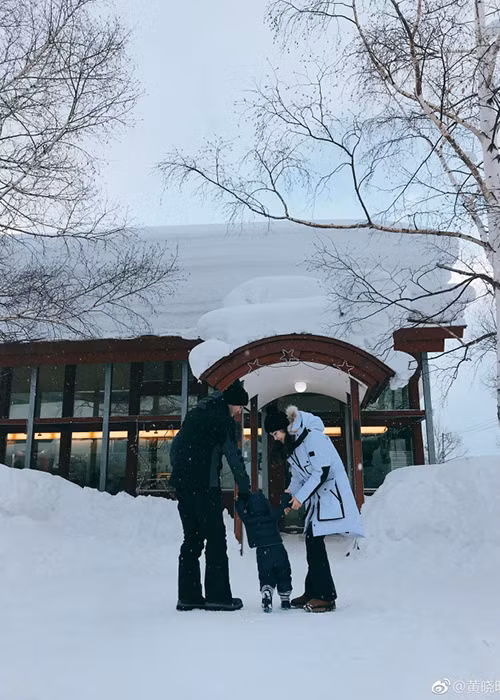Vợ chồng Huỳnh Hiểu Minh - Angelababy cùng dắt tay con trai Bọt Biển Nhỏ đi trên tuyết. Ảnh: Weibo