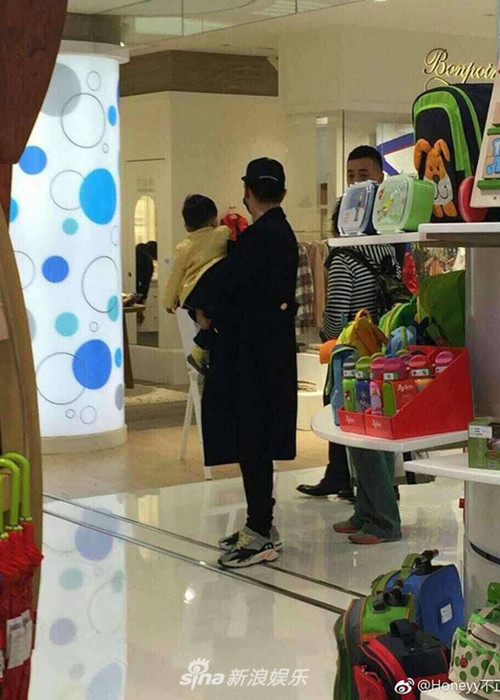 Huỳnh Hiểu Minh bồng bé Bọt Biển Nhỏ trong khi Angelababy chăm chú chọn đồ chơi cho con. Ảnh: Weibo