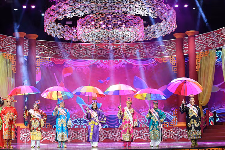 Các Táo cầm ô cầu vồng đi catwalk như người mẫu. Ảnh: VFC