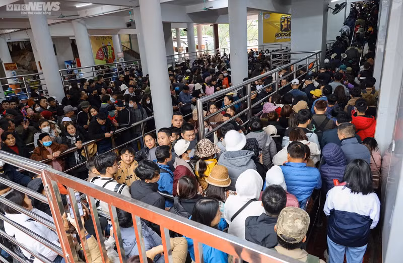 Tại khu vực lối vào cáp treo Chùa Hương chật kín người xếp hàng. Mất khoảng 15 phút chờ đợi, du khách mới có thể chen chân vào cabin để lên động Hương Tích.