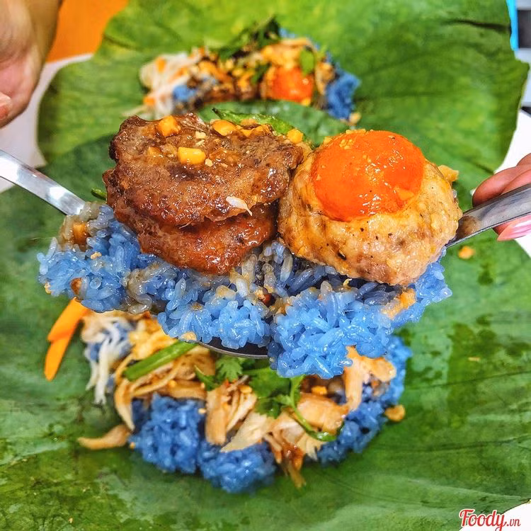 2- Xôi đậu biếc: Món xôi dùng nước cốt hoa đậu biếc trộn với nếp nấu xôi nhờ thế có màu xanh biếc cực bắt mắt. Ăn kèm với thịt gà xé, thịt heo xay, xíu mại trứng muối, chả... sẽ khiến bạn ăn mê say không dứt.