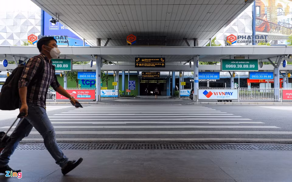 Thỉnh thoảng, chỉ có vài hành khách qua lại lối đi bộ vào ga quốc nội sân bay Tân Sơn Nhất.