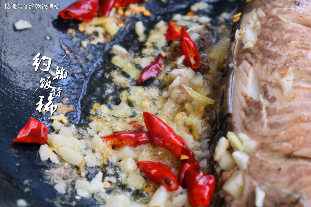 5 - Sau khi cá chín vàng cả hai mặt, chuyển cá sang một bên, cho một ít ớt khô, tỏi phi, tỏi đã cắt hạt lựu vào, phi với dầu chiên cá, thêm một lượng nước vừa đủ, bắt đầu nêm gia vị.