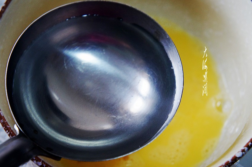 Bước 2: Dùng hai thìa nước nóng khoảng 80 độ C đổ vào hỗn hợp trứng đã đánh. Nhiều bạn lo lắng không biết làm theo cách này có làm trứng chín không, các bạn yên tâm trộn nhanh sẽ không được đâu nhé. Bạn cũng có thể thay nước bằng sữa, trẻ không thích uống sữa đây là cách bổ sung canxi tốt nhất.