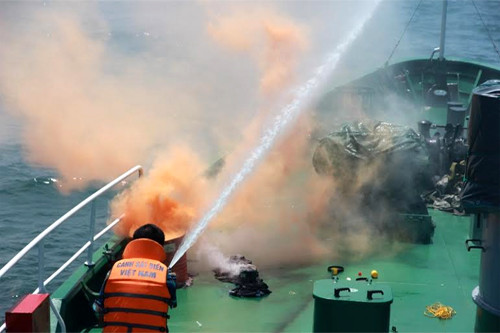 Nhận được tín hiệu cấp cứu, Cảnh sát biển Việt Nam đã lệnh cho Bộ Tư lệnh Vùng Cảnh sát biển 3 điều động Tàu cảnh sát biển 8001 đang trên đường tuần tra, kiểm soát, duy trì thực thi pháp luật trên biển, nhanh chóng cơ động đến khu vực tàu bị nạn để tìm kiếm cứu nạn; đồng thời đề nghị các tàu hoạt động gần khu vực tàu bị nạn tham gia cứu nạn khẩn cấp. Ảnh: Các chiến sĩ hạn chế ngọn lửa phát tán chờ tàu cứu hộ đến