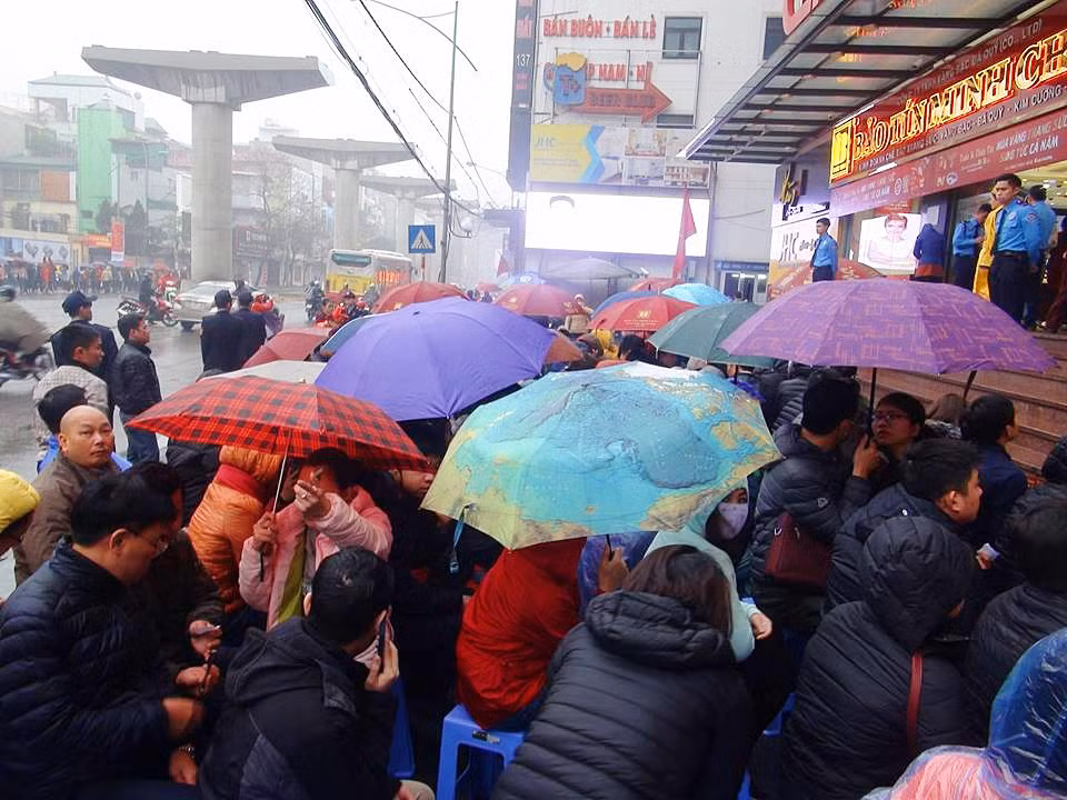 Nhiều người sẵn sàng ngồi đợi dưới mưa để chờ đến lượt.