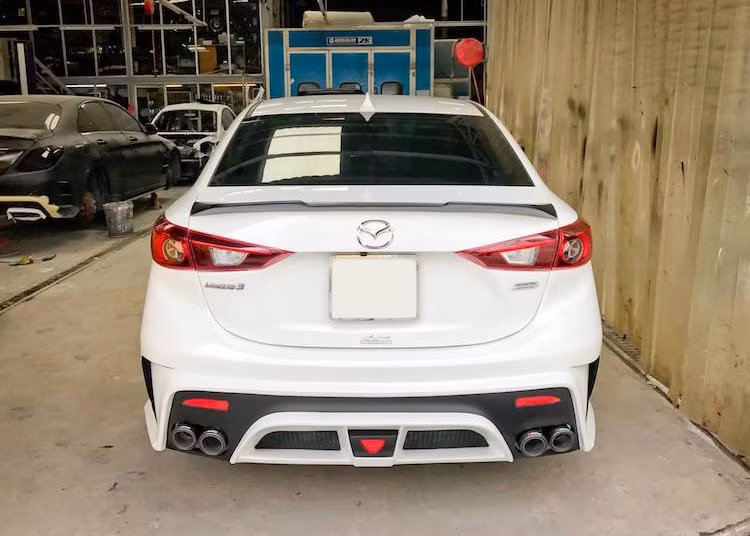 Tương tư như phía trước, cản sau của chiếc Mazda 3 này cũng đã được xưởng độ "thửa riêng", đi kèm với cặp chụp ống xả kép của Akrapovic mang đậm phong cách thể thao. Kết thúc bản độ là một cánh gió dạng nẹp được gắn trên nắp khoang hành lý.
