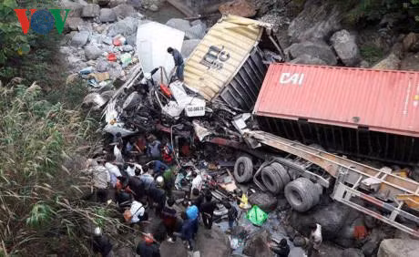 Lực lượng chức năng và người dân đang tìm cách cứu người bị nạn trong cabin xe.