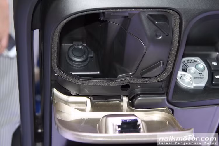 Ở bên dưới, ổ khóa của QBIX là dạng khóa từ y hệt các mẫu xe tay ga tầm trung khác của Yamaha. Tuy nhiên, chiếc xe đã có điểm cải tiến là ổ điện 12V nằm trong hộc chứa đồ, giúp người sử dụng có thể sạc các thiết bị di động như máy nghe nhạc hay điện thoại nếu có jack chuyển.