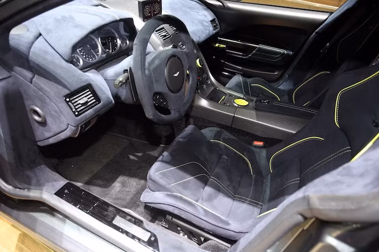 Bên trong nội thất, gần như toàn bộ các chi tiết trong cabin của Rapide AMR đã được bọc trong loại vải nhung alcantara với tên gọi "Dark Knight" và cũng viền chỉ vàng trang trí như ngoại thất. So với Rapide thường, chiếc xe còn có vành vô-lăng với thiết kế thể thao hơn.