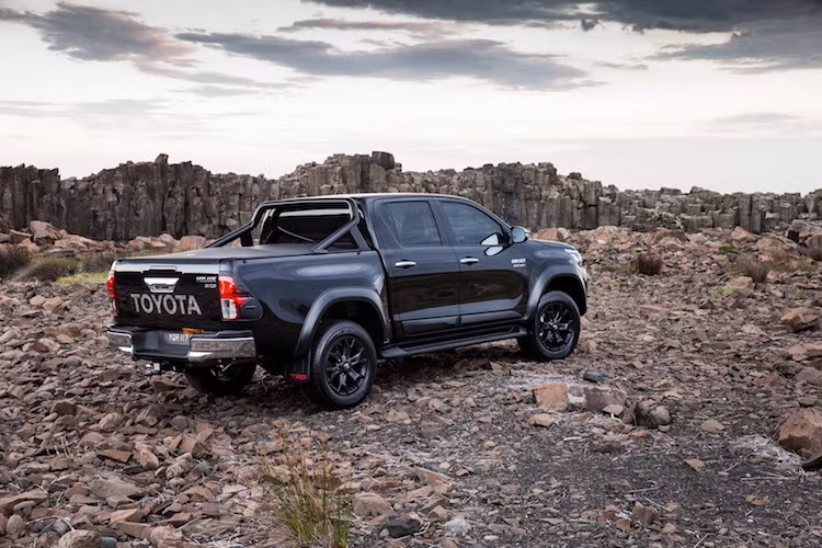 Ở hai bên thân xe, phiên bản Hilux TRD đã có thêm bậc bước chân làm bằng thép không rỉ, được sơn đen mờ với logo TRD đầy vẻ mạnh mẽ. "Dàn chân" của xe cũng được nâng cấp với mâm thể thao 6 cánh 18 inch, lốp lớn hơn nằm trong các vòm bánh được ốp nẹp nới rộng. Ở phía sau, Hilux TRD có thêm giằng thép, tấm che thùng sau và cặp đèn hậu ốp nhựa đen.