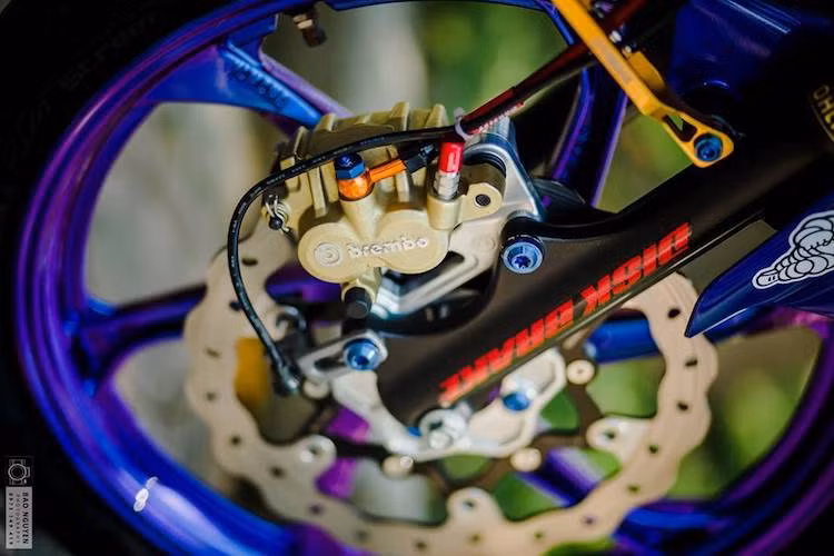 Bắt đầu từ "dàn chân" trước, chiếc xe vẫn giữ lại phuộc nguyên bản của Exciter 135. Tuy nhiên cặp mâm 5 cánh kép nguyên bản của xe đã được thay bằng mâm 6 cánh xoắn từ mẫu xe 2 kỳ Yamaha 125ZR. Trong khi đó, hệ thống phanh trước được nâng cấp với heo Brembo và đĩa Galfer.