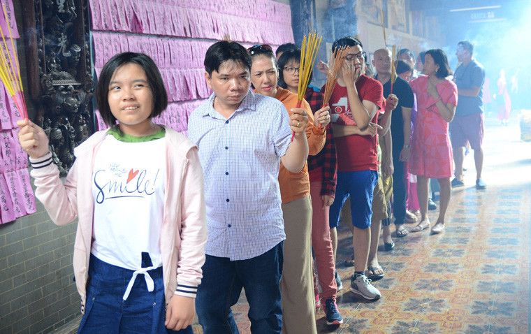 Dòng người xếp hàng dài lần lượt chờ vào chánh điện thắp nhang lễ Phật.