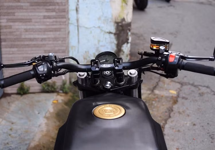 Để tạo tư thế ngồi thoải mái, tay lái nguyên bản của GS500 đã được thay bằng ghi-đông Accel bằng nhôm cao, rộng; phía trên là một đồng hồ đa chức năng nhỏ gọn. Vốn đã có bình xăng khá góc cạnh, LeeAT đã dễ dàng gò lại bình xăng của GS500 theo dáng Svartpilen