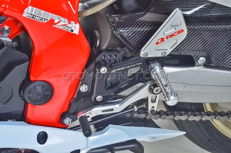 Tư thế ngồi của CBR250RR đã trở nên thể thao hơn nhờ có dàn để chân nhôm CNC từ Racing Boy. Ở hai bên thân xe là cặp chống đổ Speed Junkie, bảo vệ dàn vỏ trong trường hợp người lái "xòe" trên đường.