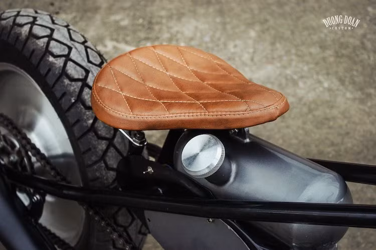 Do không còn giảm xóc phía sau nên bộ yên của xe đã được DuongDoan Design thiết kế lại toàn bộ, với lò xo đặt dưới yên theo phong cách yên xe đạp. Bề mặt yên mỏng được bọc da và chần chỉ vân con thoi cổ điển đẹp mắt.