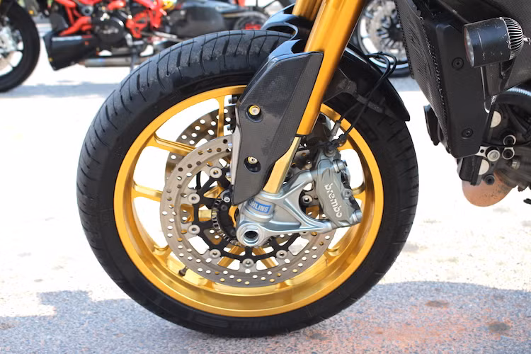 Bắt đầu từ phía trước, hệ thống phanh Brembo cùng cặp phuộc USD Ohlins của Hypermotard được giữ nguyên. Tuy nhiên thay vì mâm 5 cánh kép nguyên bản, chủ xe đã trang bị cho Hypermotard mâm có kiểu dáng tương tự nhưng là loại V-Track bằng hợp kim nhôm siêu nhẹ của Carrozzeria.