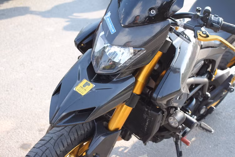Trong khi đèn pha xe vẫn có dạng nguyên bản thì ở hai bên đầu đèn trước, chủ xe đã thay cặp xi-nhan LED Rizoma Graffio gọn gàng hơn. Toàn bộ vỏ đèn pha cùng chắn bùn dưới và chắn bùn trên hình "mỏ vịt" đặc trưng của Hypermotard đã được thay bằng loại làm từ sợi carbon trần với trọng lượng nhẹ hơn và vân nổi caro đặc trưng của loại vật liệu này.