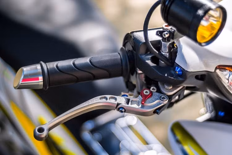 Để nhìn rõ hơn trong đêm, chủ xe đã gắn thêm một đèn LED L4 trên chân kính hậu trên tay lái. Bên dưới đèn LED, tay phanh nguyên bản của Wave đã được thay bằng tay CRG Folding, trong khi bao tay nguyên bản của Wave được giữ nguyên, chỉ có gù tay lái thay bằng gù xéo Rizoma.