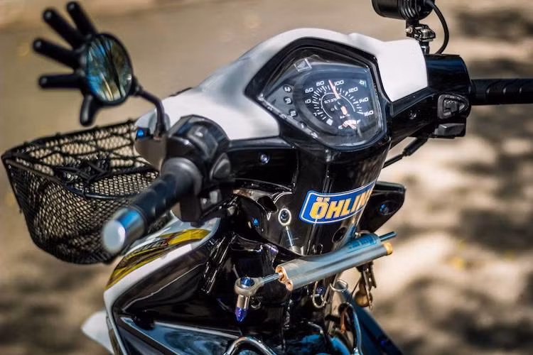 Theo phong cách kiểng Thái Lan, chiếc xe đã được lắp giỏ trước tiện dụng cùng với chiếc gương hậu hình bàn tay độc đáo. Nằm bên dưới cổ xe là cây trợ lực Ohlins được gắn vào cổ xe Wave một cách gọn gàng với pát chế và phần nhựa gáy cắt gọt khéo léo.