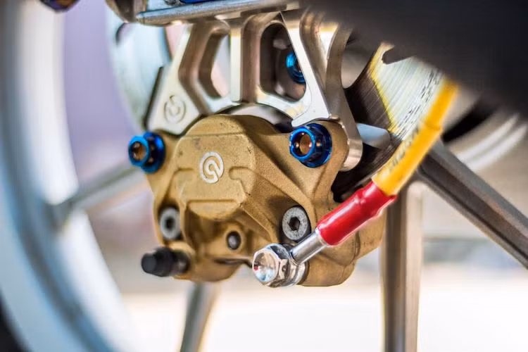 Vốn có hệ thống phanh đùm nguyên bản phía sau, tuy nhiên bản độ này đã được chủ xe nâng cấp lên phanh đĩa với heo Brembo 2 pis đối xứng pát gắn ngược, dây dầu Morin và bình dầu AEM Titan.