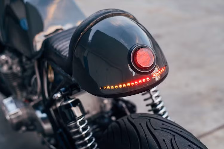 Ở phía sau, phần đuôi cafe racer đặc trưng của chiếc xe đã được Cafe Cycles tích hợp khéo léo một chiếc đèn hậu tròn và xi-nhan LED ở phía trong vỏ. Để "đồng bộ" với phuộc trước, CB550K cũng được thay cặp giảm xóc thể thao nhạy hơn cho phía sau.