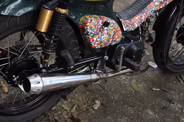 Cặp ốp che hệ thống điện và yếm ngắn trên chiếc Cub độ này đã được dán decal theo phong cách Stickerbomb, được tạo thành từ nhiều mảnh decal với hình khác nhau được dán một cách ngẫu nhiên. Về "nội công", chiếc xe đã được thay cục máy côn tay của Honda 67 nâng dung tích lên 85 cc, kèm theo chế hòa khí từ Honda Cub 82 và pô độ thủ công.