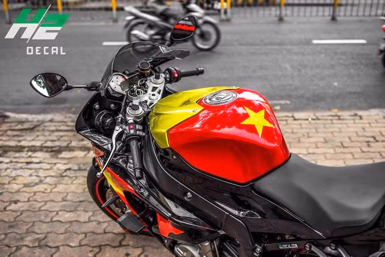 Trên nền sơn đen nguyên bản của S1000RR, những màu sắc đỏ và vàng của quốc kỳ càng trở nên nổi bật hơn. Trong khi đó ở phía trên bình xăng, phần nhựa ốp dán màu vàng kim loại kết hợp với màu đỏ quốc kỳ đã gợi nhớ về bộ giáp của nhân vật Iron Man.