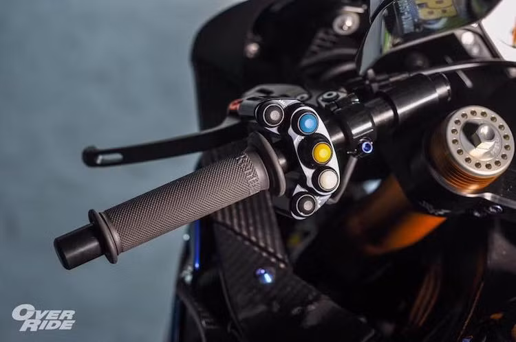 Tương tự, nắp bình xăng nguyên bản của xe cũng đã được thay thế bằng nắp CNC đóng mở nhanh theo phong cách xe đua từ Alpha Racing. Nằm phía trên tay lái của S1000RR nay cũng hội tụ một loạt "đồ chơi" độc đáo. Ngoài bao tay Renthal, chiếc xe còn có cùm công tắc rút gọn với 7 nút chức năng từ Alpha Racing.