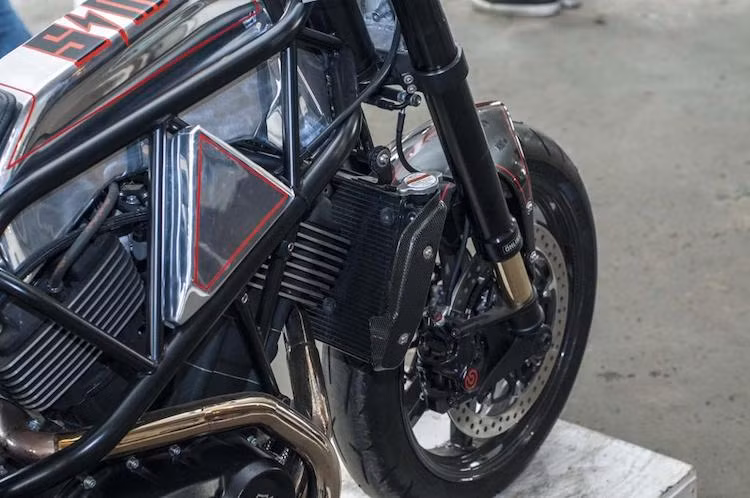 Trên bản độ này, hầu như các chi tiết nguyên bản của Street 750 đã bị loại bỏ hoàn toàn, chỉ còn giữ lại động cơ. Ở phía trước, Harley Hooligans được thay nguyên dàn phuộc USD Ohlins cắt ngắn từ Ducati Diavel, kết hợp với mâm trước BST Carbon 7 cây cùng cặp đĩa phanh Ducati, heo Brembo Caliper .484 và dè trước thể thao.