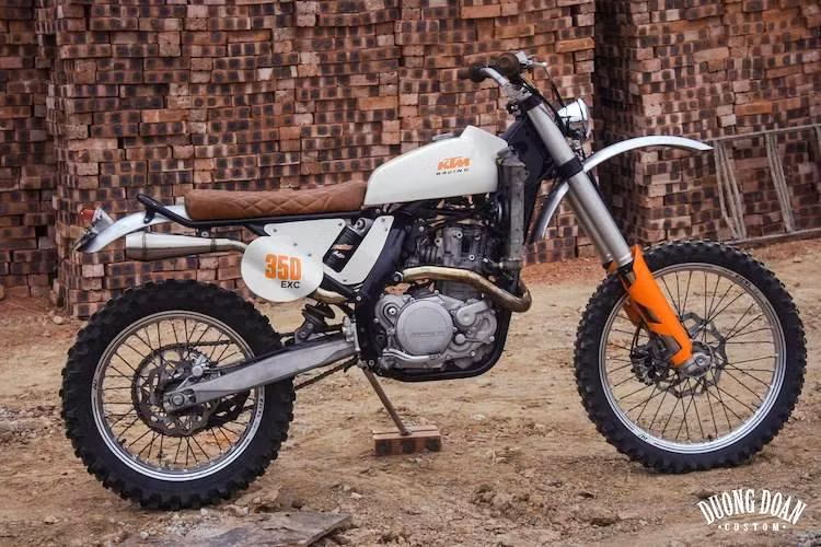 Vốn có kiểu dáng "cào cào" hiện đại, chiếc 350 EXC đã được một vị khách người Canada đang sinh sống và làm việc tại Việt Nam đem tới xưởng DuongDoan Design ở Hà Nội với một yêu cầu duy nhất: "mang lại hơi thở classic cho chiếc xe". Chính vì vậy, xưởng độ này đã "biến hóa" lại chiếc xe theo phong cách vintage enduro.