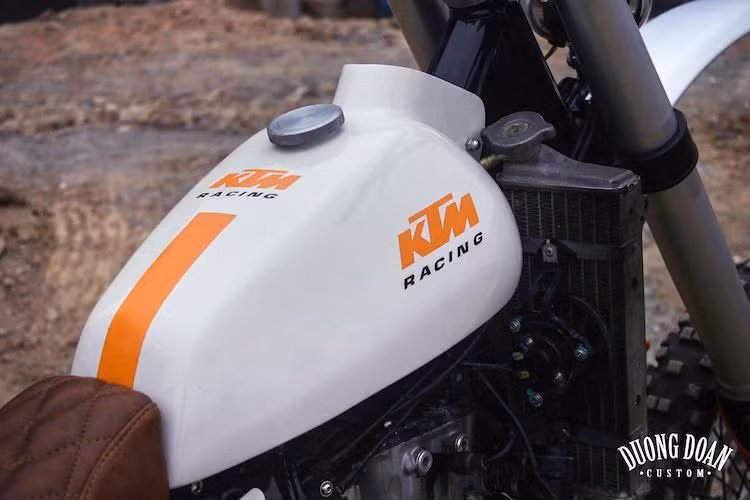 Vốn có thân xe vỏ nhựa nguyên khối chạy từ trước ra phía sau, tuy nhiên DuongDoan đã tách rời bình xăng của xe ra bằng cách gò lại một bình khác cho 350 EXC với dáng truyền thống. Giống nhiều bản độ khác của xưởng, chiếc xe cũng mang nhiều chi tiết tinh tế như bao tay vân con thoi Biltwell hay nắp bình xăng bằng nhôm CNC.
